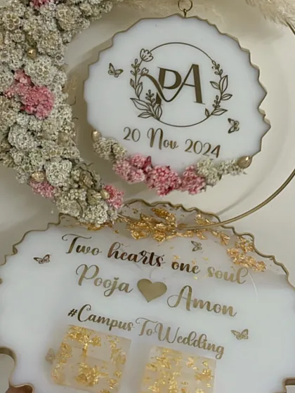 A classic white and gold ring platter with a floral hoop. This design is personalized with the couple's names and a 'Campus to Wedding' hashtag.