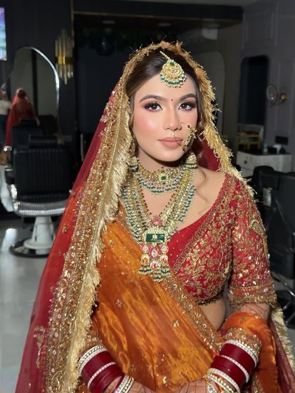 A close-up of this bride's radiant makeup. We used soft contouring and a warm, glowing highlight to enhance her features, pairing it with a classic bridal nath and maang tikka.