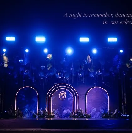 For a Sangeet night that’s all about glamour and rhythm, we designed this eclectic stage with dramatic blue lighting and modern arches. It set the perfect mood for an evening of dance battles, dhol beats, and non-stop celebration.