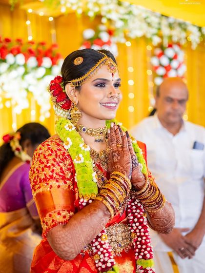 These photos capture the beautiful moments of a traditional wedding. The bride's red silk saree is draped to stay perfect through all the ceremonies, from sitting at the mandap to seeking blessings.