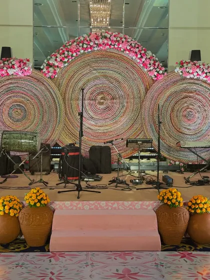 The stage backdrop for a musical performance during the ceremony, using woven textures and floral accents.