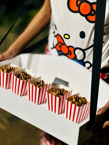 A pass-around tray with popcorn drizzled in chocolate, part of a Hello Kitty-themed menu. This shows our ability to create fun, whimsical, and delicious food for any theme.