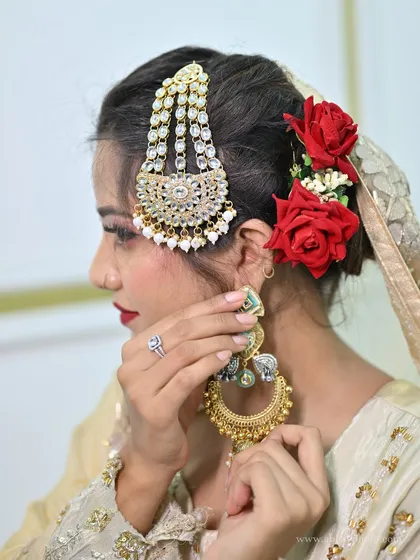A close-up on the details that matter. This image showcases a beautiful Pakistani-style jhoomar and oversized chandbali earrings, highlighting the intricate Kundan work and pearl detailing that can elevate any bridal or festive outfit.