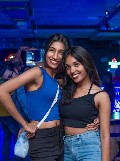 Two friends looking stunning in the blue light of the pub.