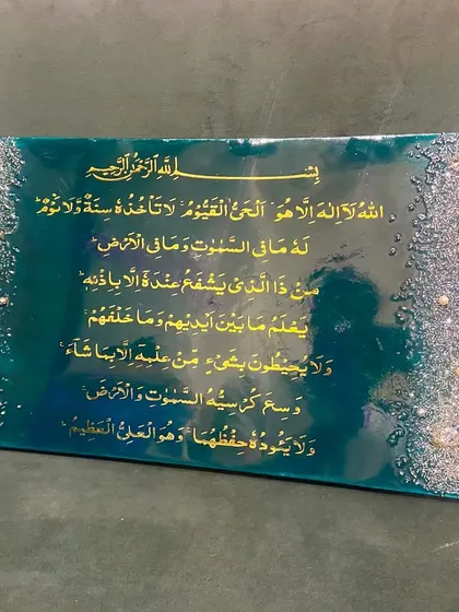 An elegant Ayat ul Kursi plaque in a rich emerald green and gold color scheme. The borders are adorned with a cascade of crystals and pearls, adding a touch of luxury to the sacred verse.