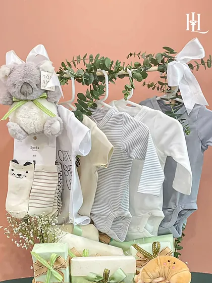 Another angle of the neutral-toned baby clothing hamper, highlighting the soft fabrics and the elegant arrangement with eucalyptus leaves.