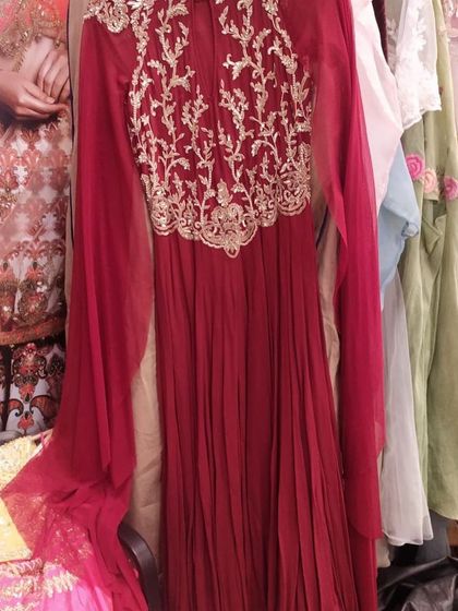 This deep red Anarkali gown features exquisite gold embroidery on the yoke and dramatic, flowing sleeves. It's a regal and powerful statement piece for a wedding reception or major festive celebration.