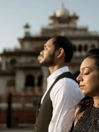 A moment of peace and serenity with Jaipur's Albert Hall Museum in the background. The couple stands with their eyes closed, soaking in the sun and the quiet energy of the morning.