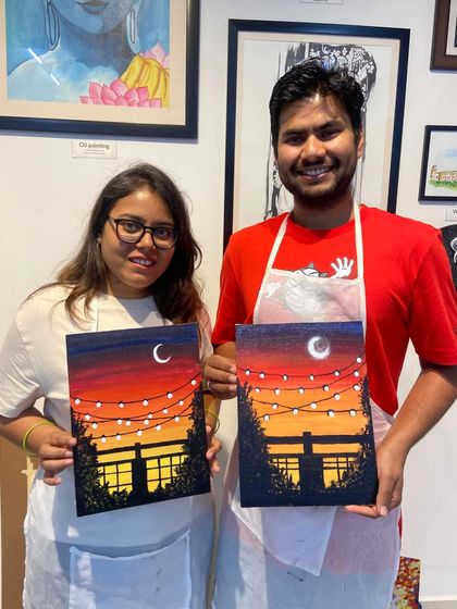 A couple with their finished sunset paintings. Creating art together is a wonderful way to connect and make memories.