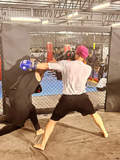 Using the cage to your advantage. A fighter works to control his opponent, demonstrating how to use the environment as a tool in an MMA fight.
