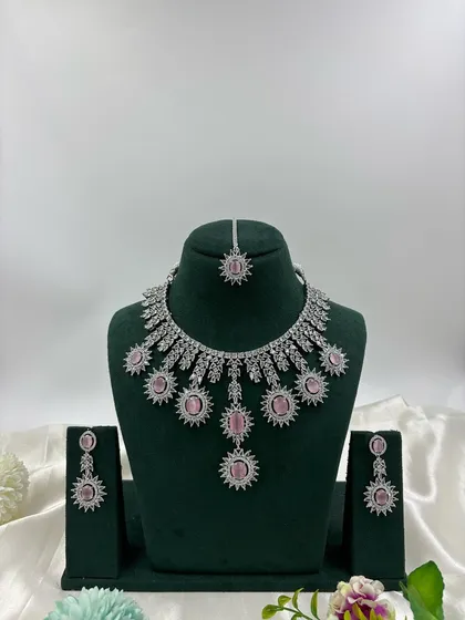 Showcasing the modern side of our collection, this silver-plated American Diamond set features a unique sunburst design. It's available in multiple stone colors including white, black, and mint green, perfect for cocktail parties and contemporary tastes.