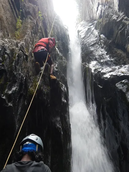 A team member making his way down a technical section of Knotty Canyon. You can see the belayer below, always ensuring a backup for safety.