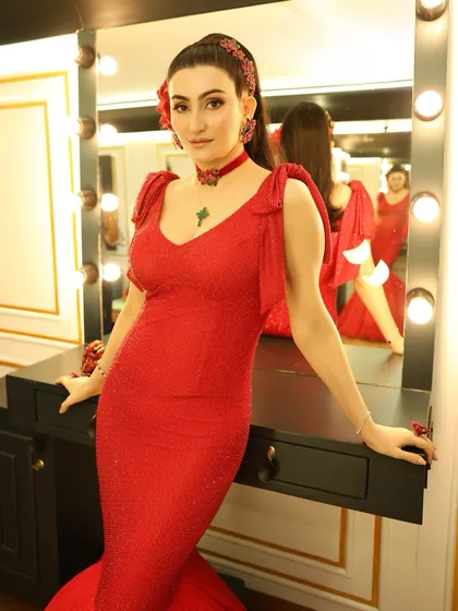 A final portrait before the show. The hair, makeup, and styling all work in harmony to create a look that is both bold and sophisticated, perfect for a high-visibility media event.