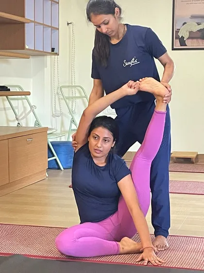 My goal is to empower you to become a certified yoga expert. This image captures a moment of dedicated learning, where one of my instructors provides precise, hands-on assistance to a student mastering an advanced posture.