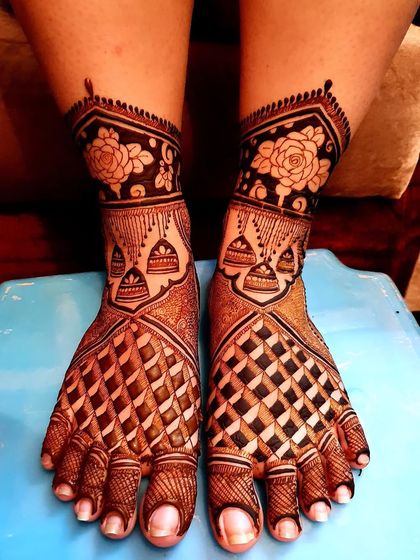 A classic bridal foot design featuring bold geometric patterns and delicate floral details around the ankles. The dark stain shows the quality of my natural henna.