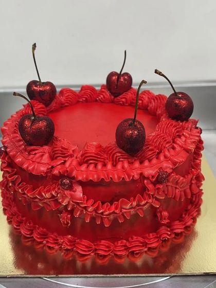 A still photo of the royal red vintage cake. The deep red frosting and intricate piping details give it a luxurious, velvety look that's perfect for a special occasion.