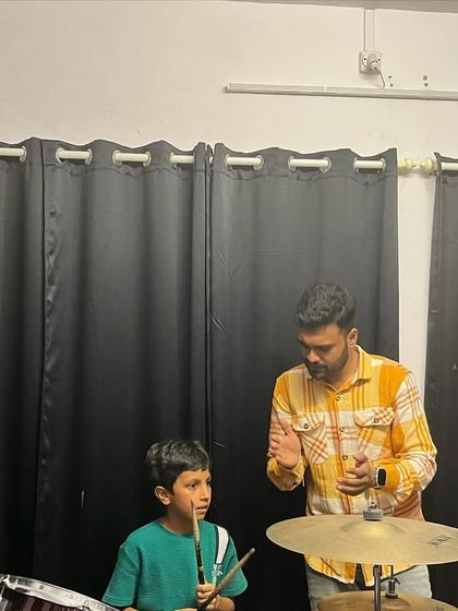 A teacher gives some last minute advice to a young drummer before his performance at the jam session. We are there to support our students every step of the way.