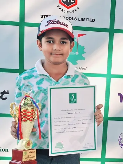 A close-up of Taanush Kumar with his winner's trophy and certificate from the NCR Cup.