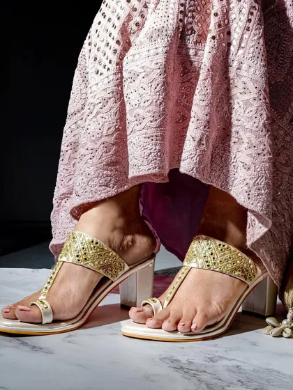 A lifestyle footwear shoot that places the product in a real-world context. The focus is on the intricate details of the sandal while showing how it complements an outfit, making it more desirable for the customer.