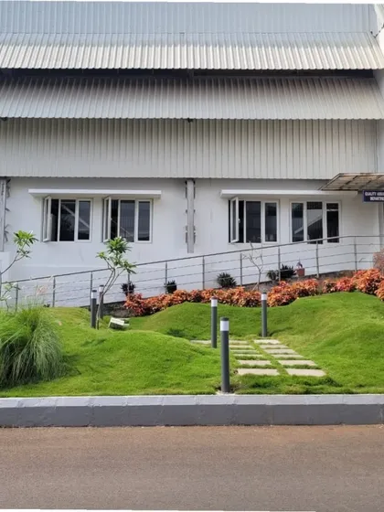 Even industrial sites can be softened and humanized with thoughtful landscape design. Here, sculpted earth mounds covered in grass and colorful shrubs create a playful and welcoming entry sequence next to a factory building.