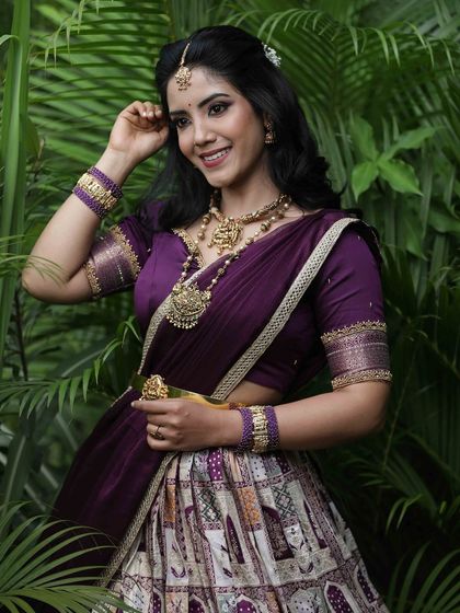 A portrait capturing the model's happy expression, framed by the lush greenery that complements her purple attire.