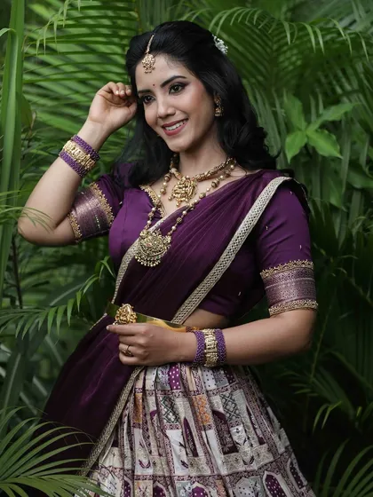 A portrait capturing the model's happy expression, framed by the lush greenery that complements her purple attire.