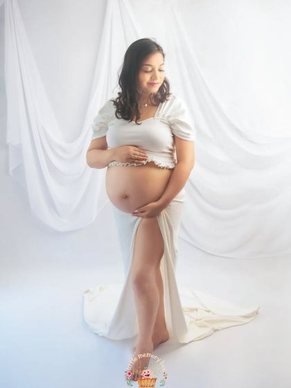 In this pose, the mom-to-be gently cradles her bump, creating a feeling of peace and connection. The all-white theme emphasizes the purity and beauty of this special time.