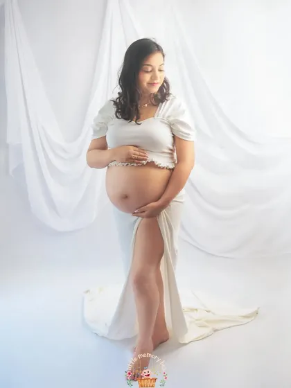 In this pose, the mom-to-be gently cradles her bump, creating a feeling of peace and connection. The all-white theme emphasizes the purity and beauty of this special time.