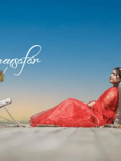 A beautiful, colorful shot of a couple relaxing by traditional boats, with "Humsafar" text, making it a perfect title page for a romantic album.