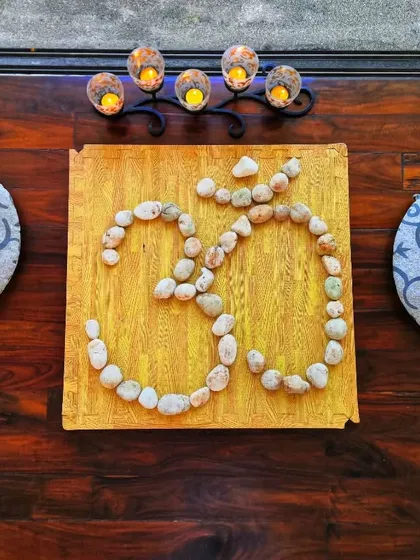 The 'Om' symbol, crafted from stones, sits at the center of our practice space. It represents the universal sound of creation and the ultimate union that practices like Surya Kriya aim to achieve.