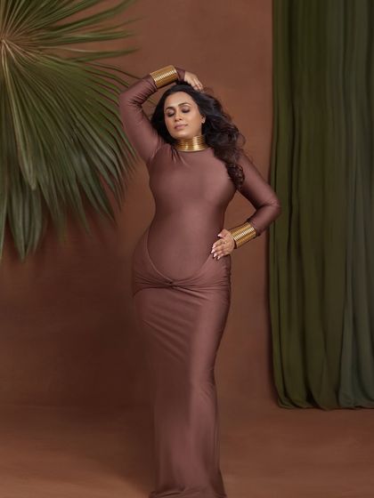A powerful and statuesque pose in a form-fitting brown gown, accented with gold jewelry for an Egyptian goddess feel.
