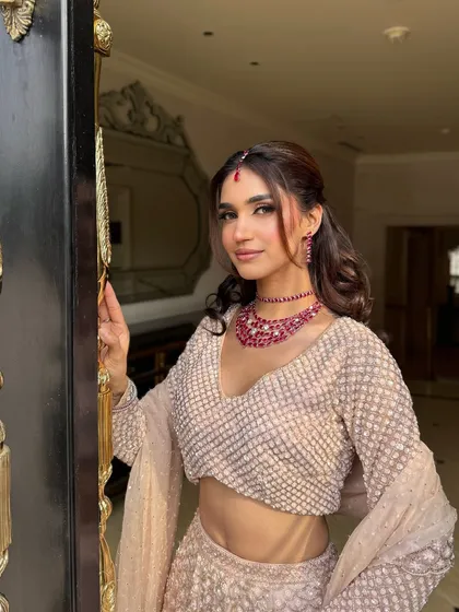 A welcoming smile from the bride at the door. Her makeup looks fresh and radiant, perfect for greeting guests at her engagement party.
