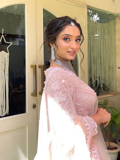 A beautiful side profile of the client, showing how the soft tendrils of her updo frame her face and create a delicate silhouette.