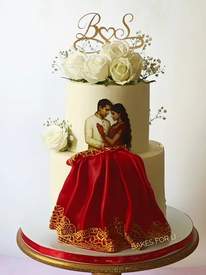 I designed this unique two-tier wedding cake to capture the couple's portrait in an artistic way. The bride's flowing red lehenga is crafted from edible lace, creating a stunning 3D effect that makes the cake truly one-of-a-kind. It’s a beautiful blend of personal art and delicious flavor for your engagement or wedding.