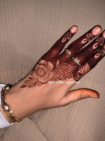 A simple rose design on the back of the hand, showing the beauty of a single, well-placed motif.