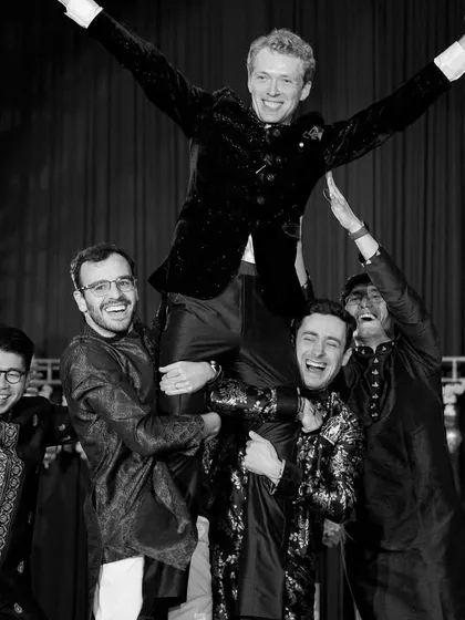 The pure joy of a sangeet performance. The groom is lifted up by his friends in celebration at the end of their high-energy dance.