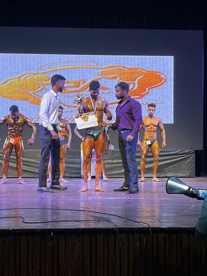 Onstage at the Mr. India competition. My athlete receiving his award, showcasing the physique we built together.