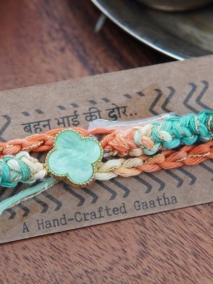 A close-up of the Clover Rakhi on its backing card.