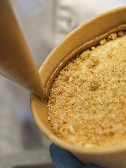 Piping dulce de leche onto the biscuit base of our Banoffee Pie.