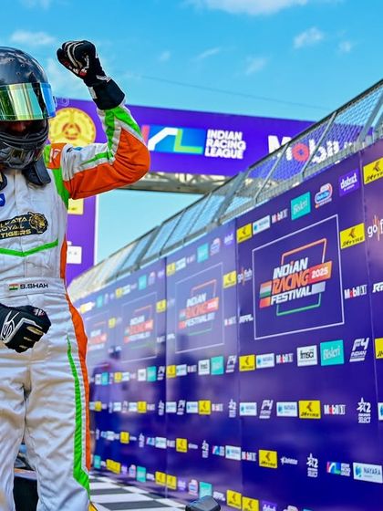 A driver celebrates a victory at the Indian Racing Festival. We create the perfect backdrop for these triumphant moments with extensive branding and a professional podium setup.