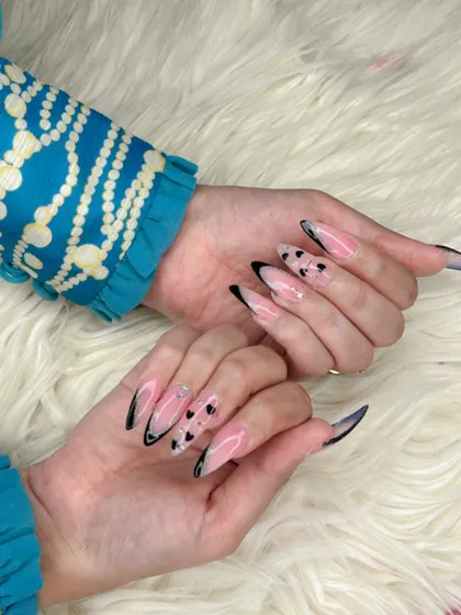 For those who love dramatic length, these long stiletto acrylic extensions are a perfect choice. The design features a modern French tip with delicate black heart art for a playful yet edgy vibe.