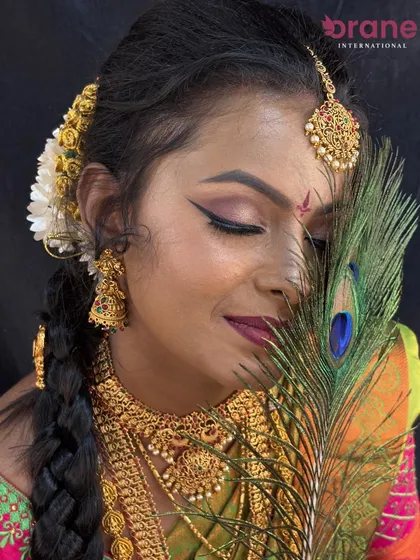 This pose highlights the traditional braided hairstyle adorned with flowers, a key element of South Indian bridal beauty.
