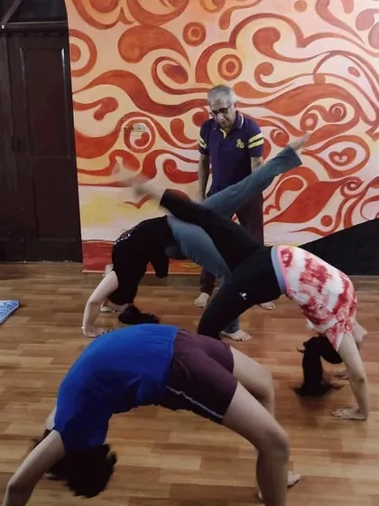 This is a glimpse from one of our evening yoga sessions. I am observing my students as they practice different variations of Chakrasana (Wheel Pose), ensuring everyone is supported. My goal is to create a space where everyone can challenge themselves safely.