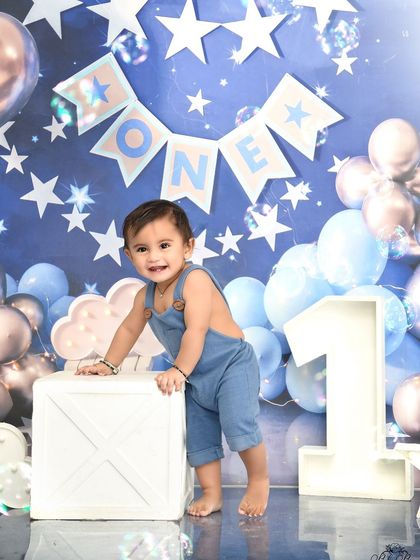 Standing tall and proud for his first birthday. The starry night theme with blue and silver balloons makes for a celestial celebration.