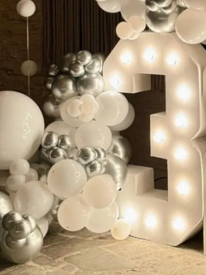 A close-up on the detail of the white and silver balloon garland, showing the mix of sizes that creates that beautiful, cloud-like effect.