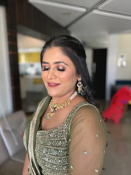 A soft and warm makeup look for this client in an olive green lehenga. The gold-toned eyeshadow and nude lip are a classic combination.