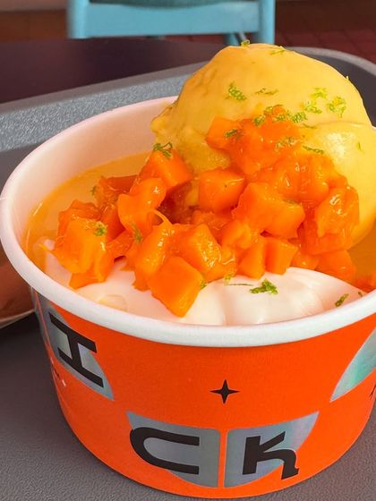 A refreshing mango dessert to cool you down. This cup has creamy coconut sago, topped with a scoop of bright mango sorbet, fresh mango chunks, and a little lime zest. It's a perfect sweet treat after a spicy meal.