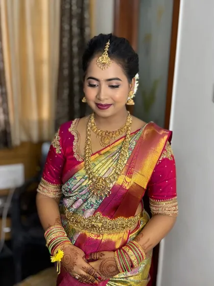 A full view of Komal's naming ceremony look. She is wearing a multi-colored silk saree with heavy gold jewellery.