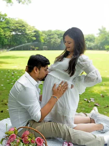 A classic and tender bump kiss, captured in the fresh, natural setting of a park. The love between them is so evident.