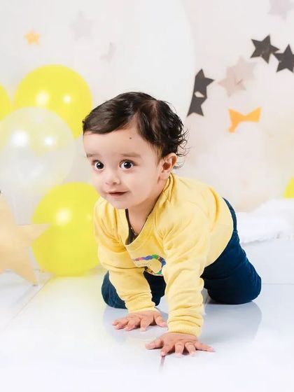 A baby boy on the move! This action shot captures him crawling during his first birthday photoshoot, full of energy and excitement.